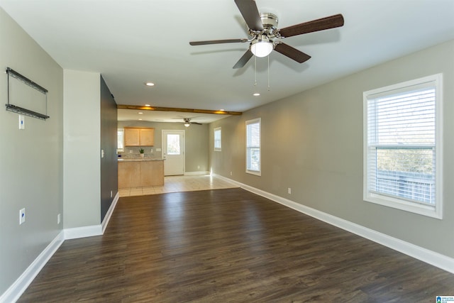 unfurnished living room featuring ceiling fan, dark hardwood / wood-style floors, and a healthy amount of sunlight