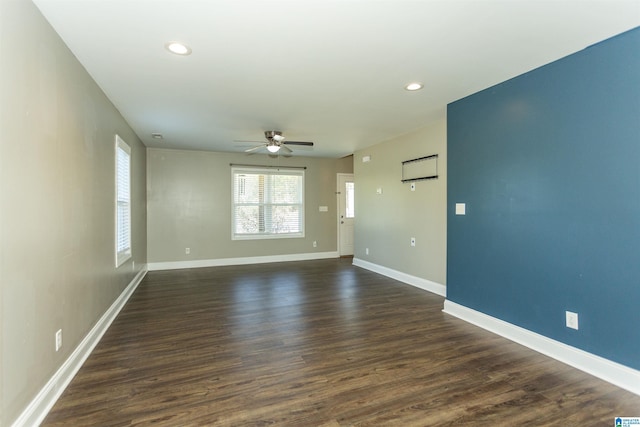 empty room featuring dark wood-type flooring and ceiling fan