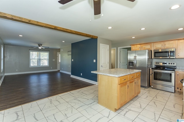 kitchen with stainless steel appliances, a center island, beamed ceiling, and ceiling fan