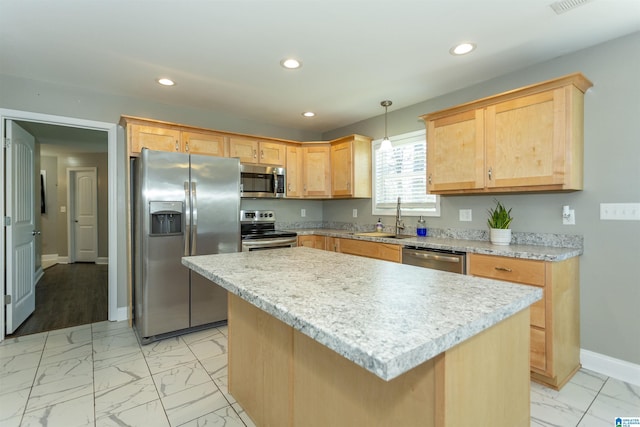 kitchen with pendant lighting, appliances with stainless steel finishes, a kitchen island, light brown cabinets, and sink