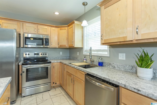 kitchen featuring appliances with stainless steel finishes, sink, decorative light fixtures, light stone counters, and light brown cabinets