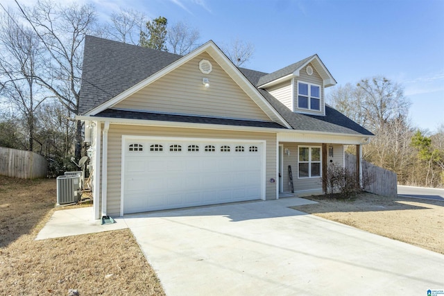 view of front of home featuring a garage, central AC unit, and covered porch