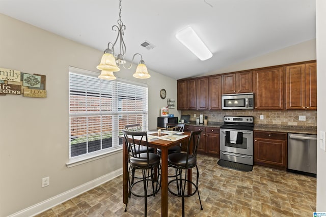 kitchen with vaulted ceiling, decorative light fixtures, tasteful backsplash, a notable chandelier, and stainless steel appliances