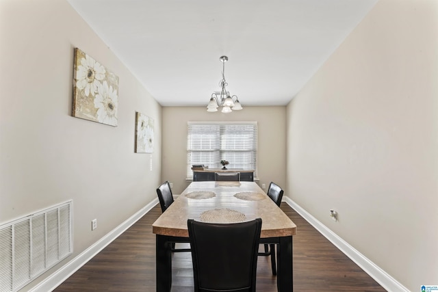 dining area with dark hardwood / wood-style flooring and a chandelier