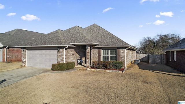 view of front of property with a garage, central AC, and a front yard