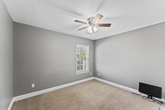 spare room with ceiling fan and light colored carpet