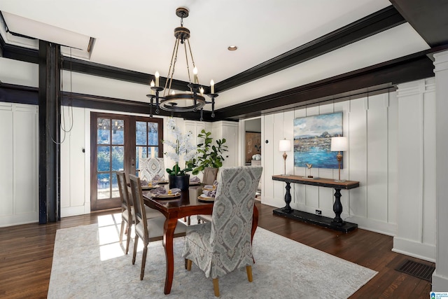 dining room featuring french doors, ornamental molding, dark hardwood / wood-style flooring, and an inviting chandelier