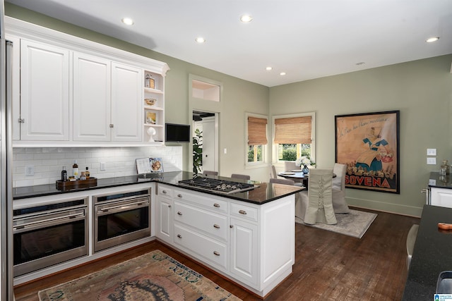 kitchen featuring kitchen peninsula, white cabinets, and appliances with stainless steel finishes