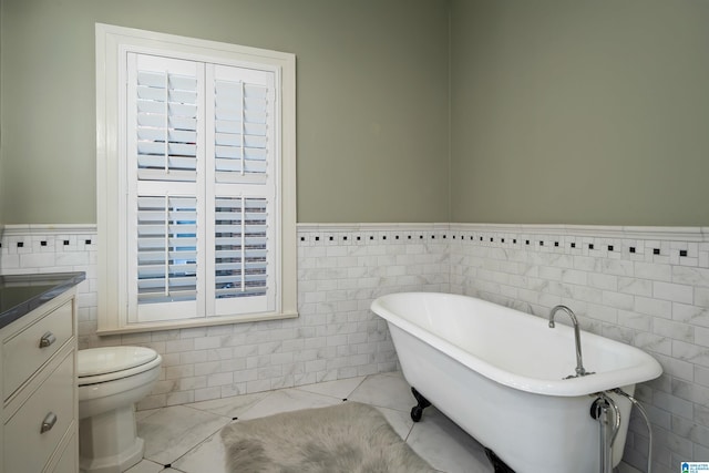 bathroom featuring vanity, toilet, a bathing tub, and tile walls