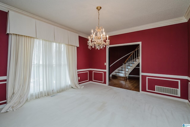 carpeted empty room featuring ornamental molding and a notable chandelier