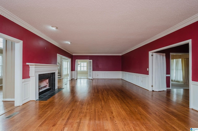 unfurnished living room with hardwood / wood-style flooring, crown molding, and a textured ceiling