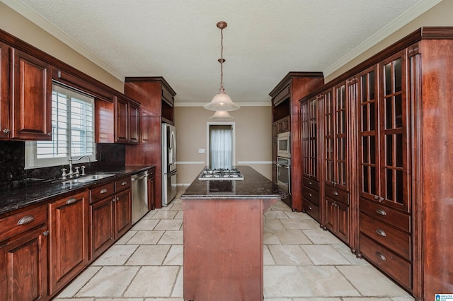 kitchen with appliances with stainless steel finishes, sink, backsplash, hanging light fixtures, and a center island