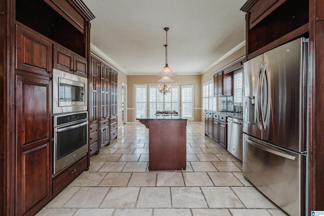 kitchen with a kitchen island, pendant lighting, stainless steel appliances, crown molding, and an inviting chandelier