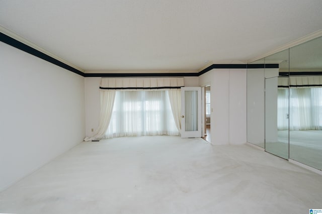 empty room with light colored carpet, ornamental molding, and elevator