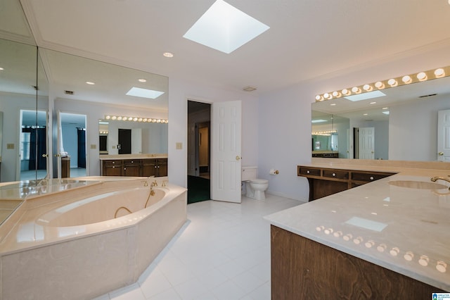 bathroom with a skylight, a relaxing tiled tub, vanity, tile patterned floors, and toilet