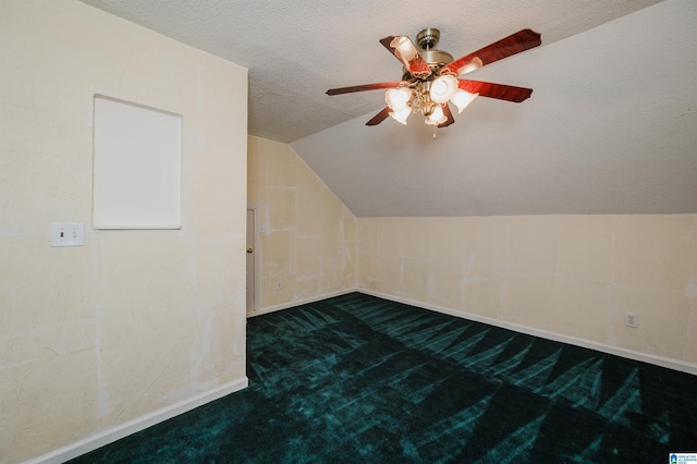 additional living space with ceiling fan, lofted ceiling, carpet flooring, and a textured ceiling