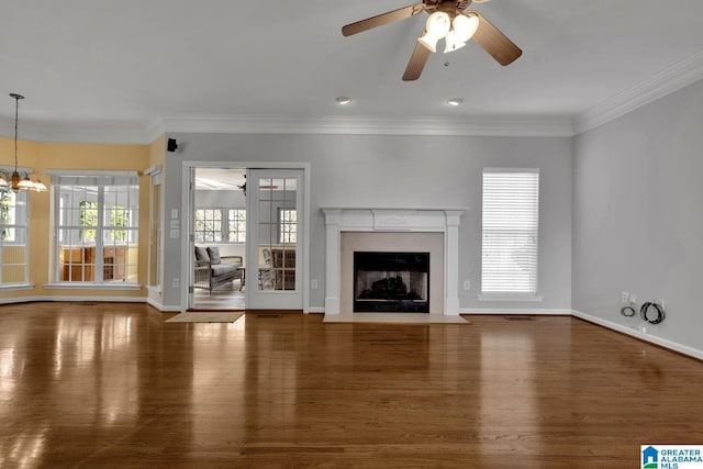 unfurnished living room featuring crown molding, ceiling fan with notable chandelier, and dark hardwood / wood-style flooring