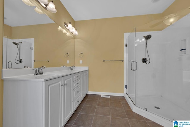 bathroom with walk in shower, vanity, and tile patterned flooring