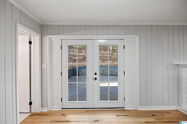 doorway featuring crown molding, light hardwood / wood-style flooring, and french doors