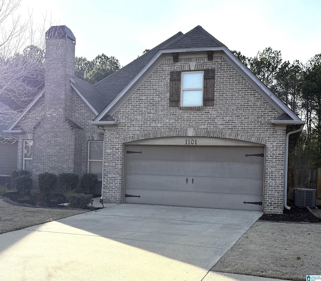 front of property featuring central air condition unit and a garage