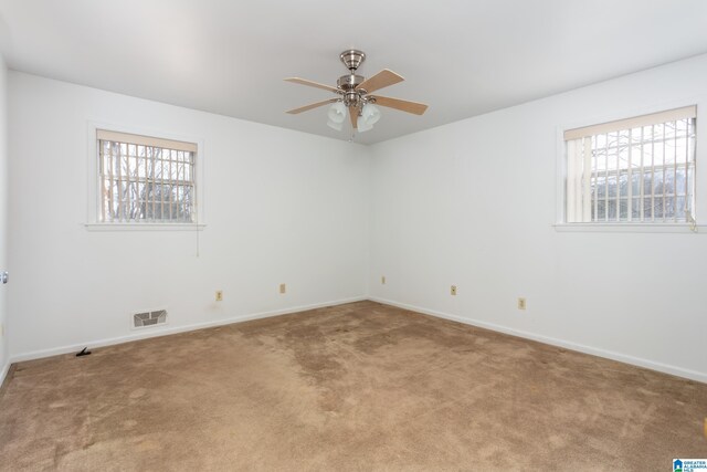 spare room featuring a wealth of natural light, light colored carpet, and ceiling fan