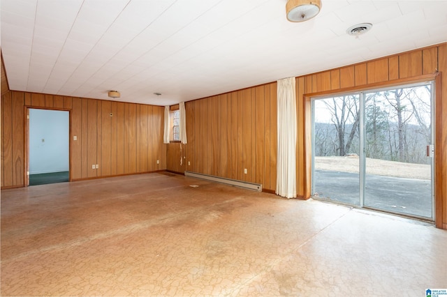 unfurnished room with a baseboard radiator and wooden walls