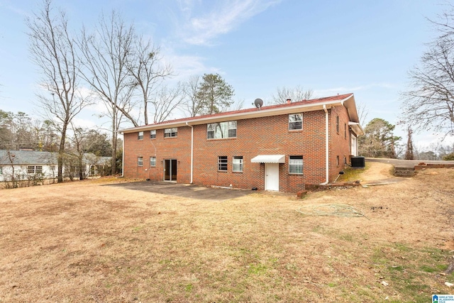 back of property featuring central AC unit, a patio area, and a lawn