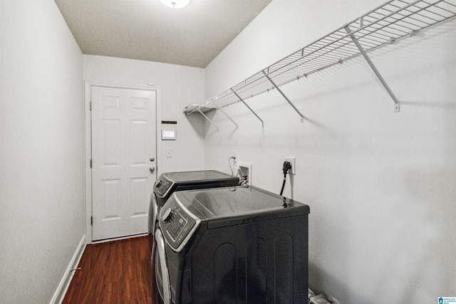 clothes washing area featuring dark hardwood / wood-style floors and washer and dryer