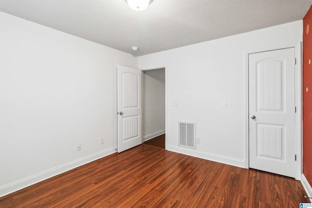 spare room with dark wood-type flooring