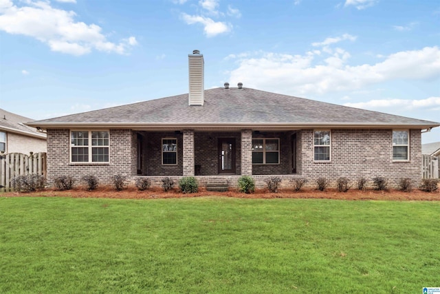 rear view of property featuring a lawn