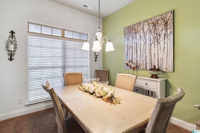 dining area with a chandelier and dark carpet