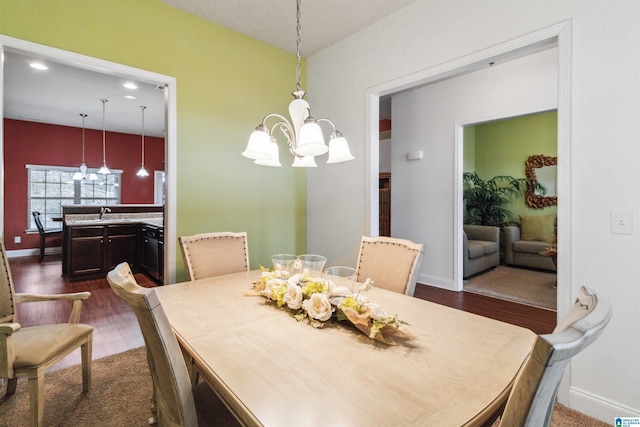 dining area featuring dark wood-type flooring and a chandelier