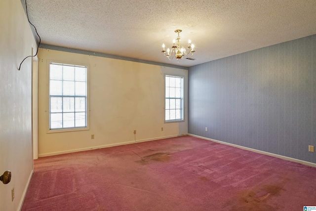 unfurnished room with carpet, a wealth of natural light, and a chandelier