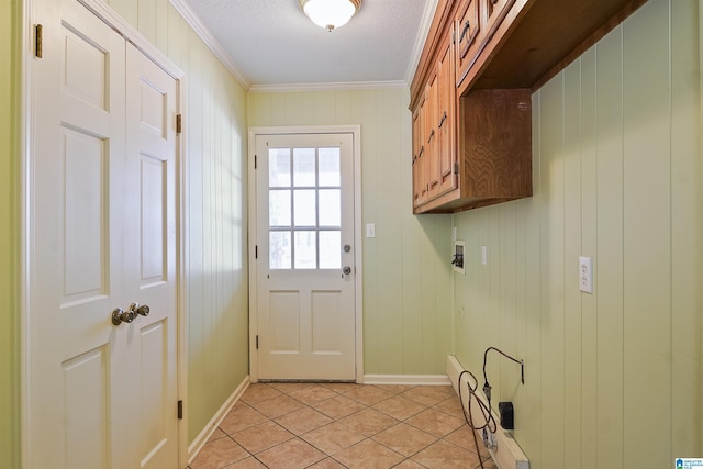 laundry room with cabinets, crown molding, light tile patterned flooring, and a textured ceiling