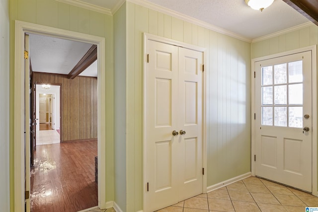 doorway featuring ornamental molding, a textured ceiling, and light tile patterned flooring