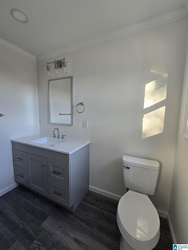 bathroom with vanity, hardwood / wood-style floors, ornamental molding, and toilet