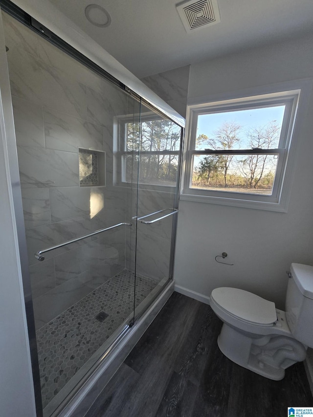 bathroom with a shower with door, wood-type flooring, and toilet