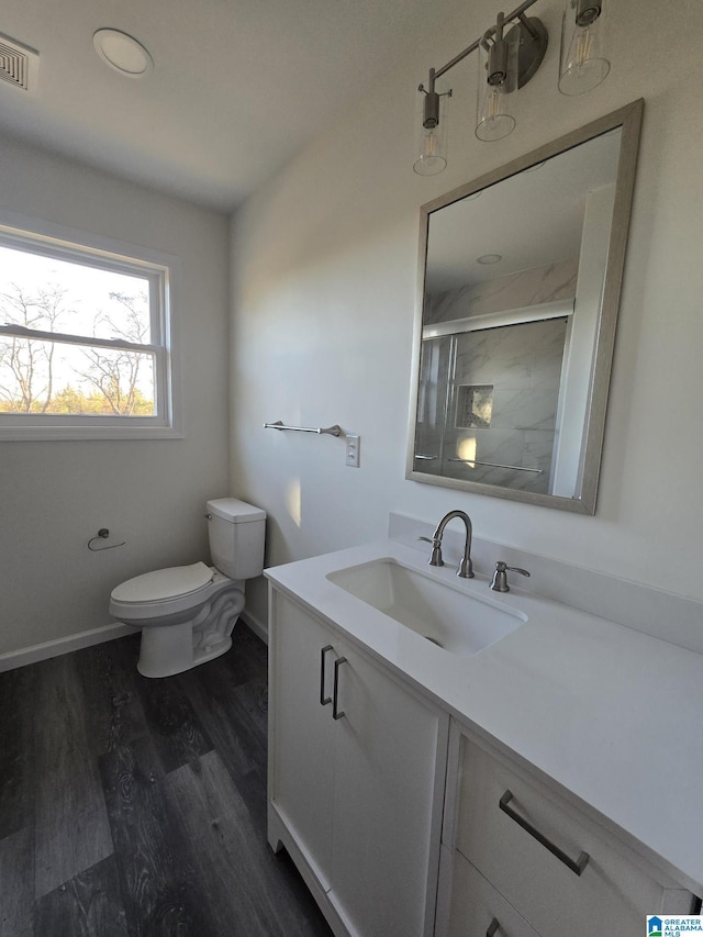 bathroom featuring vanity, toilet, hardwood / wood-style floors, and walk in shower