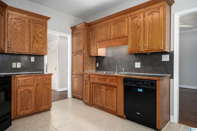 kitchen featuring tasteful backsplash, stove, black dishwasher, and sink