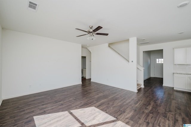 unfurnished living room with dark hardwood / wood-style floors and ceiling fan