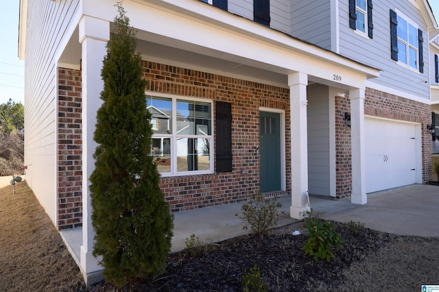 view of exterior entry with a garage and covered porch