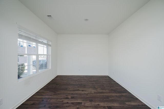 spare room featuring dark wood-type flooring