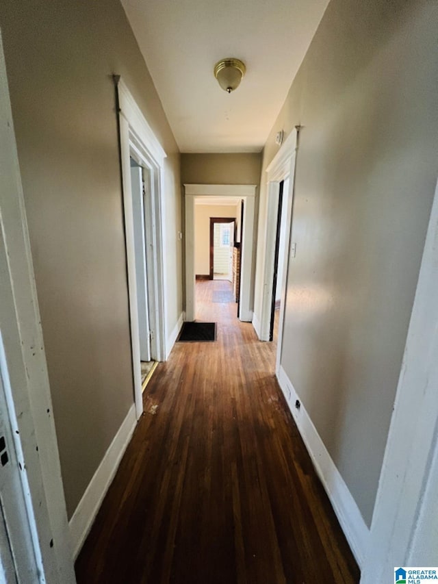 corridor with dark hardwood / wood-style flooring