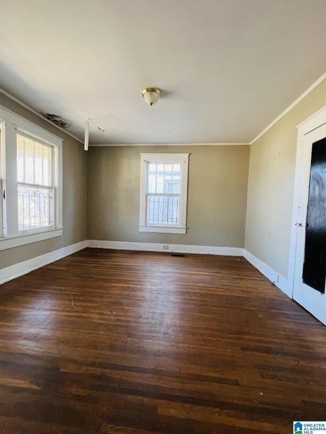 empty room featuring ornamental molding and dark hardwood / wood-style floors