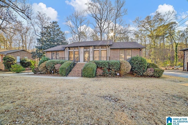 view of home's exterior with a lawn and a sunroom