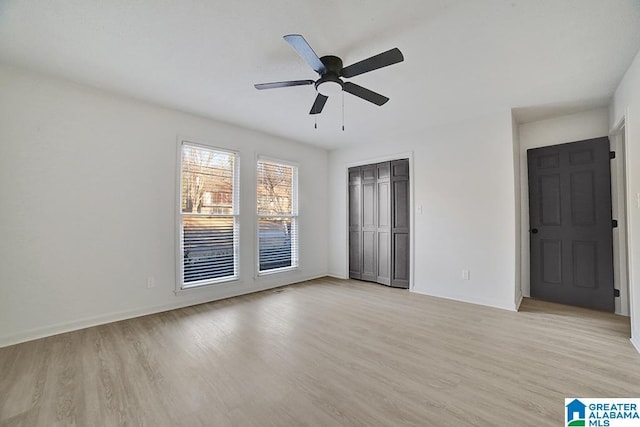 empty room with ceiling fan and light hardwood / wood-style flooring