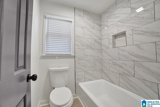 bathroom featuring tiled shower / bath and toilet