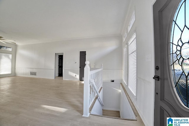 foyer with crown molding, ceiling fan, and light hardwood / wood-style flooring