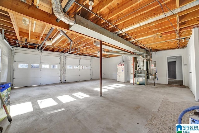 garage featuring heating unit and water heater