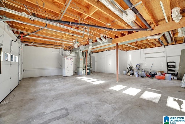 garage featuring water heater and heating unit